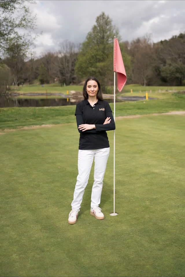 Penélope junto a la bandera de un green